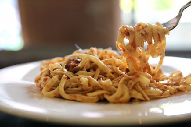 Spaghetti Bolognese mit Rinderhackfleisch und Tomatensauce, garniert mit Parmesankäseparmesan und Basilikum, italienisches Essen