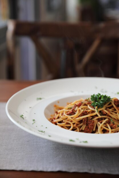 Foto spaghetti bolognese mit rindfleisch-tometo-sauce auf holztisch, italienisches essen