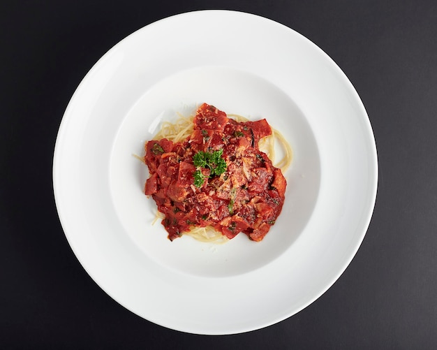 Spaghetti Bolognese mit Schinken auf schwarzem Hintergrund von oben