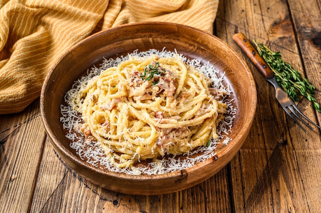 Spaghetti Carbonara macarrão com pancetta, ovo, queijo parmesão duro e molho de natas. Fundo de madeira. vista do topo.