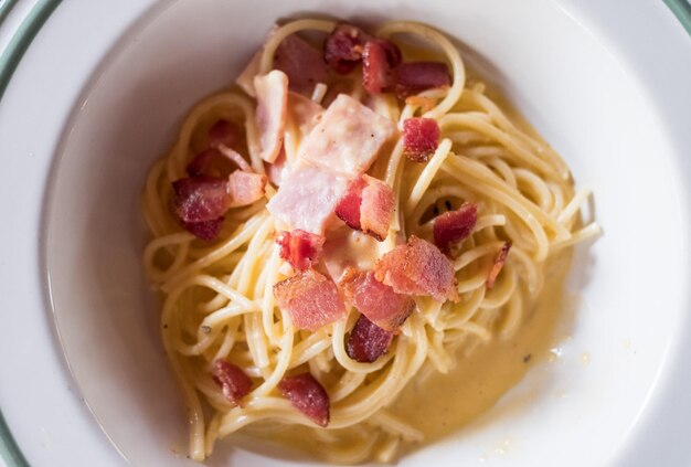 Spaghetti Carbonara mit Speckschinken in weißer Schüssel