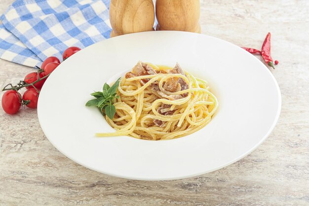 Spaghetti-Carbonara-Nudeln mit Speck, serviert mit Basilikumblättern