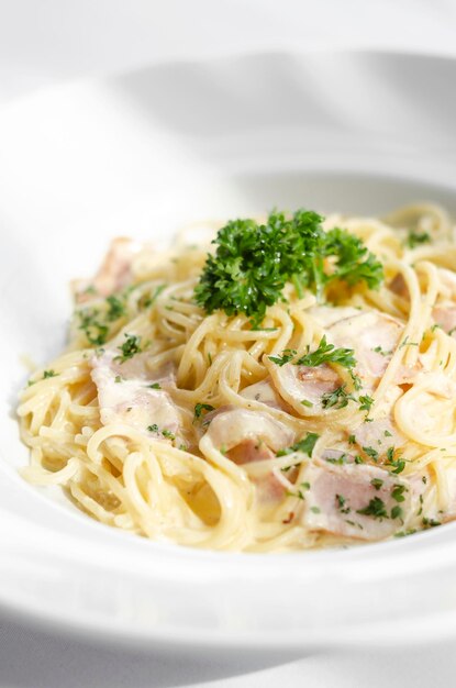 Foto spaghetti-carbonara-pasta-gericht auf weißem tischhintergrund