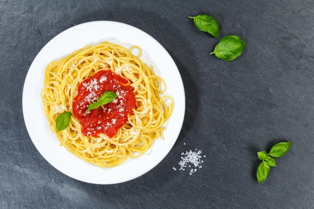 Spaghetti-Essen aus Italien Pasta-Mittagessen mit Tomatensauce von oben auf einer Schiefertafel