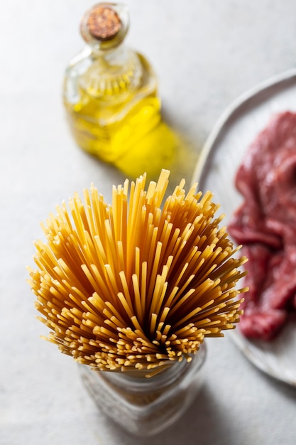 Foto spaghetti im glas und fleisch auf telleranordnung