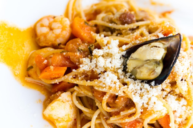 Spaghetti marina servido com molho pomodoro de frutos do mar e vegetais mistos.