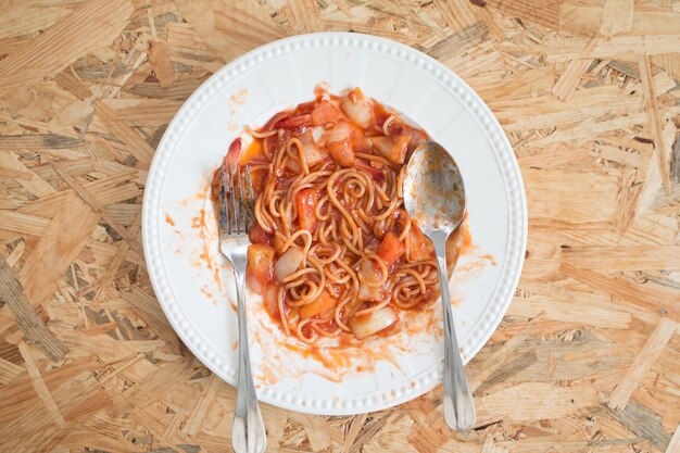 Spaghetti marisco com Molho Saviço em prato branco na mesa de madeira na cantina