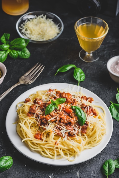 Spaghetti mit Bolognese-Sauce, geriebenem Parmesan-Käse und frischen Basilikumblättern