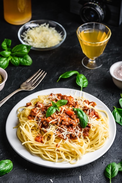 Spaghetti mit Bolognesesauce, geriebenem Parmesan und frischen Basilikumblättern