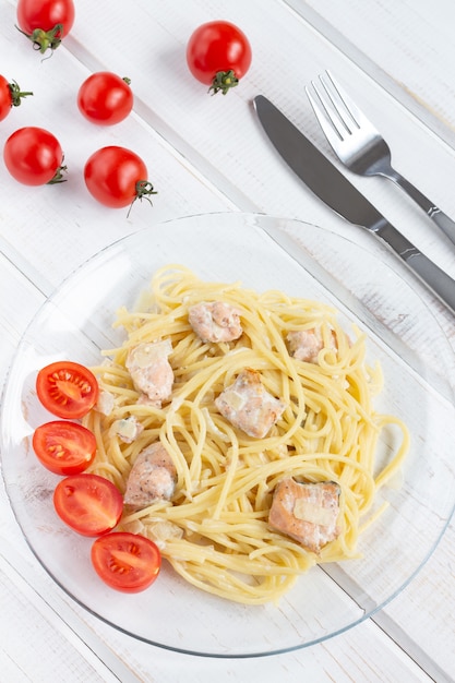 Spaghetti mit fisch auf einer transparenten glasplatte