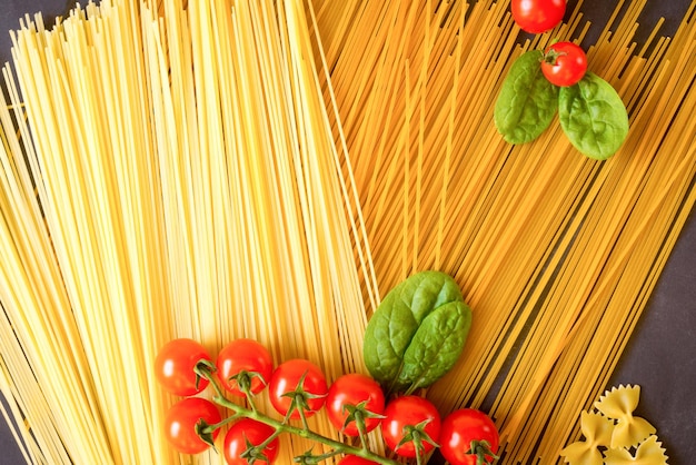 Spaghetti mit Gemüse auf dunklem Hintergrund Kirschtomaten-Spinat flach liegen