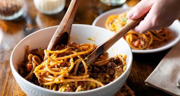 Spaghetti mit Holzlöffeln aus der Schüssel servieren