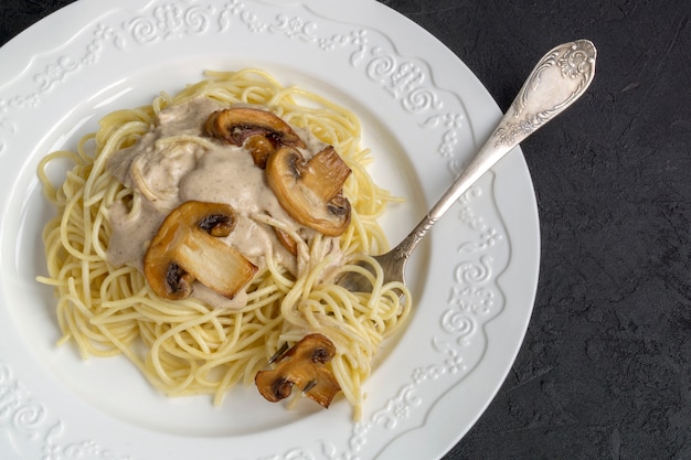 Spaghetti mit Pilzen in Sahnesauce. auf dunkel