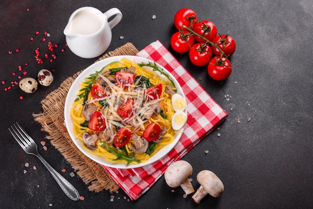 Spaghetti mit Pilzen, Käse, Spinat, Rukkola und Kirschtomaten. Italienisches Gericht, mediterrane Kultur