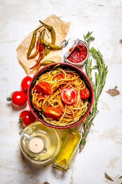 Spaghetti mit Tomatenmark, scharfen Chilischoten und Olivenöl. Auf rustikaler Oberfläche. Draufsicht