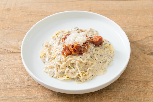 Spaghetti mit Trüffel-Sahne-Sauce und Champignons auf Teller