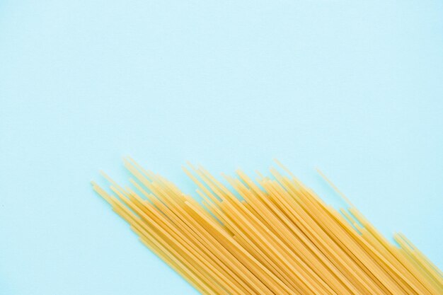 Foto spaghetti-nudeln auf blauem hintergrund von oben