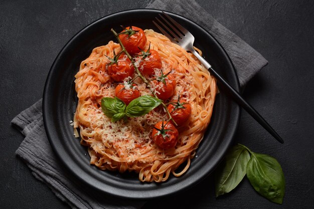 Spaghetti-Nudeln mit Kirschtomaten, garniert mit Basilikumblatt