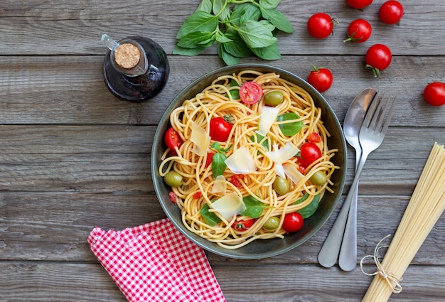 Spaghetti-Nudeln mit Tomaten, Basilikum, Oliven und Parmesan. Gesundes Essen. Vegetarisches Essen.
