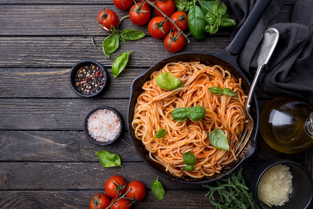 Spaghetti-Nudeln mit Tomatensauce und Basilikum über Holz