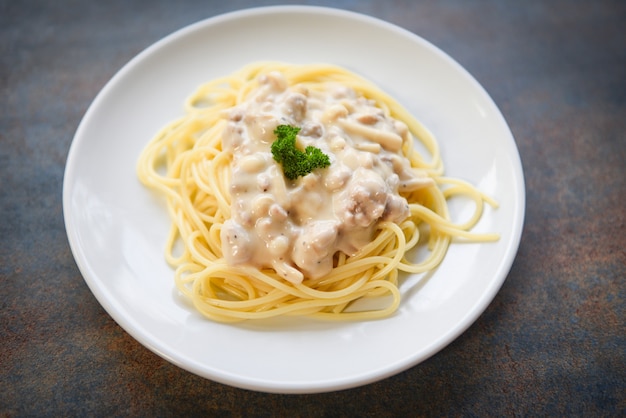 Spaghetti pasta italiana servida en un plato blanco con perejil en el restaurante
