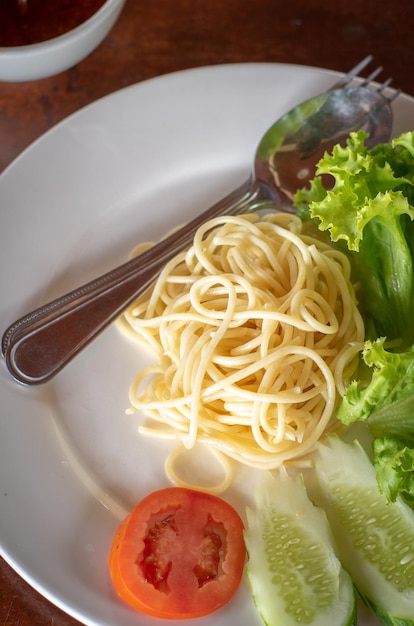 Spaghetti Pasta und Tomatensauce Knoblauch und Gewürze mit Käse und Gabel in einer Salatplatte