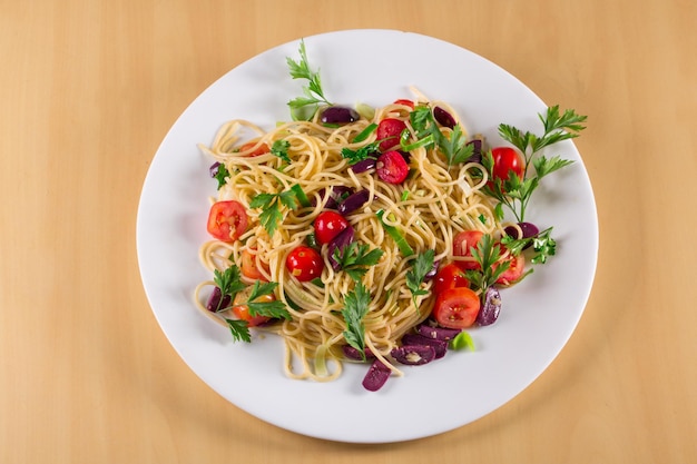 Spaghetti puttanesca spaghetti mit schwarzen oliven und kirschtomaten draufsicht