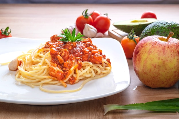 Spaghetti und frische Tomaten mit Gewürzen auf Holzbrettern.