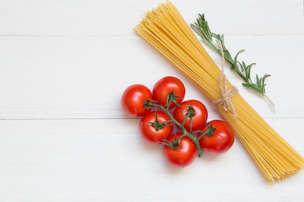 Foto spaghetti-zutaten, tomate, rosmarin, konzept auf weißem hintergrund