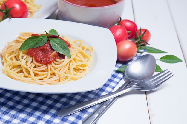 Spaghettiteigwaren mit und Tomatensauce auf hölzernem Hintergrund