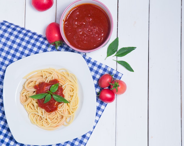 Spaghettiteigwaren mit und Tomatensauce auf hölzernem Hintergrund