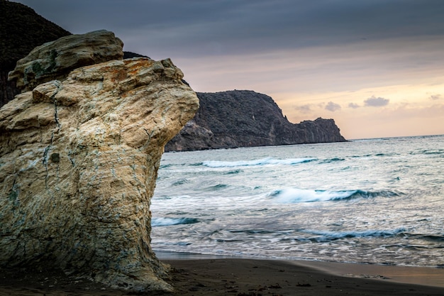 Spanien Strand bei Sonnenaufgang mit großen Felsen im Sand