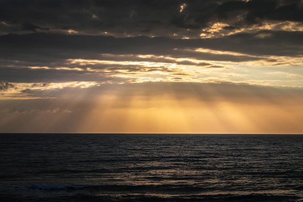 Spanien Strand bei Sonnenaufgang mit großen Felsen im Sand