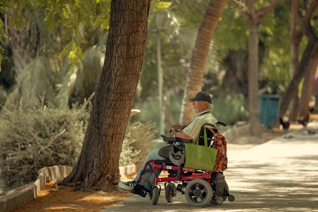 Spanien29. Juni 2022 Ein älterer Mann im Rollstuhl fotografiert in einem Park