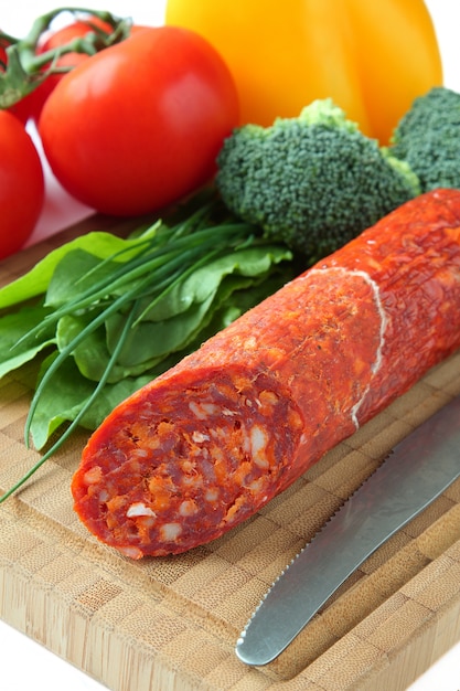 Spanische Chorizo-Wurst mit Gemüse auf einem Holzbrett