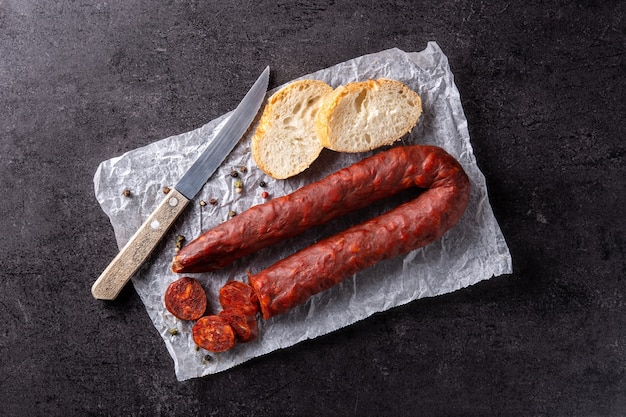 Spanische Chorizo-Wurst und Brot auf schwarzem Tisch