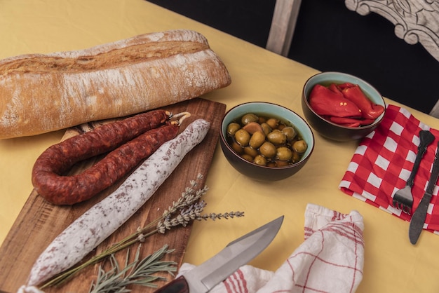 Spanische Fuet-Salami und frischer Salbei auf rustikalem Holzbrett