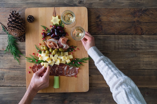 Spanische Käse- und Wurstplatte in Form eines Weihnachtsbaums Zwei Personen essen Platz kopieren