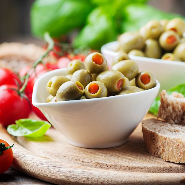 Spanische Oliven in Schüssel mit Brot und Tomaten