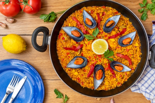 Spanische Paella auf Pfanne auf hölzernem Hintergrund