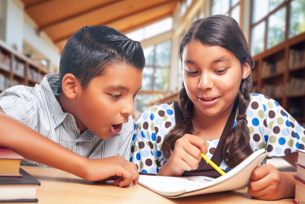 Spanische Schulkinder machen gemeinsam Hausaufgaben in der Bibliothek