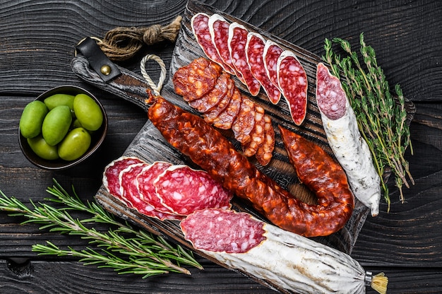 Spanische Tapas geschnittene Würstchen Salami, Fuet und Chorizo auf einem hölzernen Schneidebrett