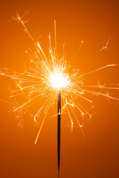 Foto sparkler de fiesta pequeños fuegos artificiales en naranja
