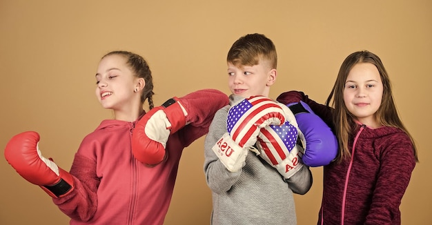 Sparring amigável Conceito de esporte americano Crianças praticando habilidades de boxe Esporte de boxe Comece a carreira de boxe Habilidades de autodefesa Meninos e meninas amigos usam luvas de boxe com a bandeira dos eua