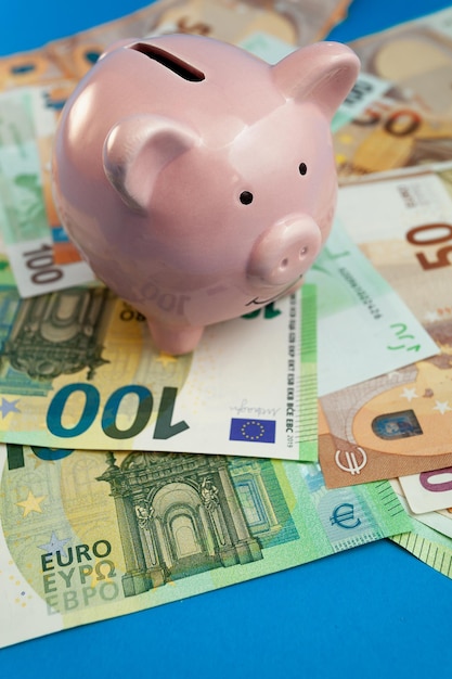 Sparschwein auf dem Hintergrund von Euro-Banknoten auf blauem Hintergrund