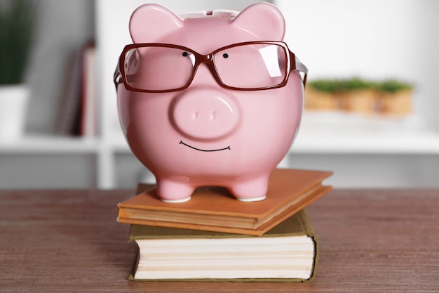 Foto sparschwein in gläsern mit büchern zu hause oder im büro