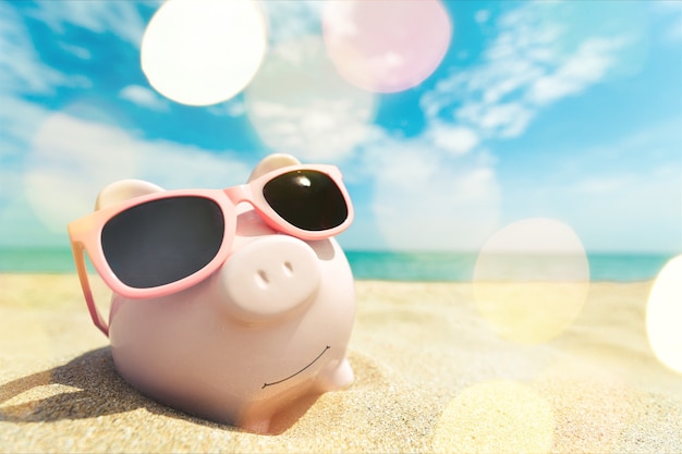 Sparschwein mit Sonnenbrille am Strandsand