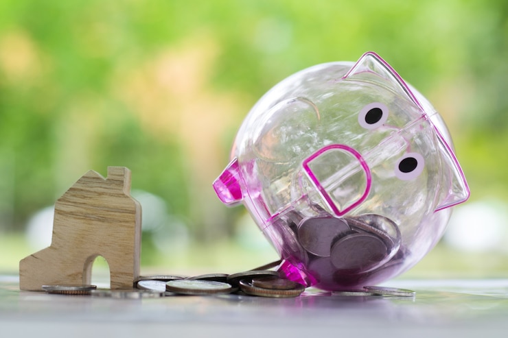 Foto sparschwein- und geldmünzen nähern sich miniaturhaus.