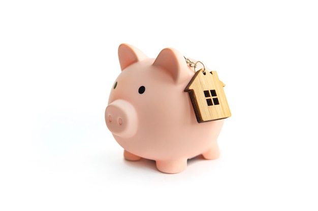 Sparschwein und Schlüsselhaus isoliert gegen weißen Hintergrund. Das Konzept des Sparens für Ihre Immobilie. Miete sparen.