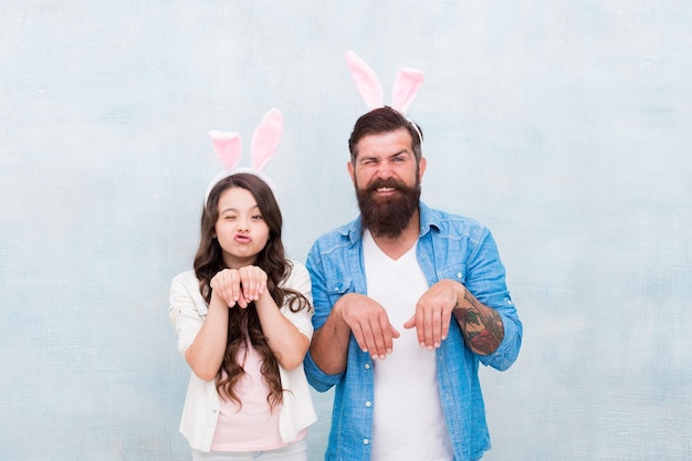 Spaß an Ostern haben Lächelnder Vater und Tochter Häschen Familienspaß glückliche Zeit mit der Familie Tragen von Hasenohren für den Frühlingsurlaub Tochter und Vater jagen Eier für den Osterurlaub